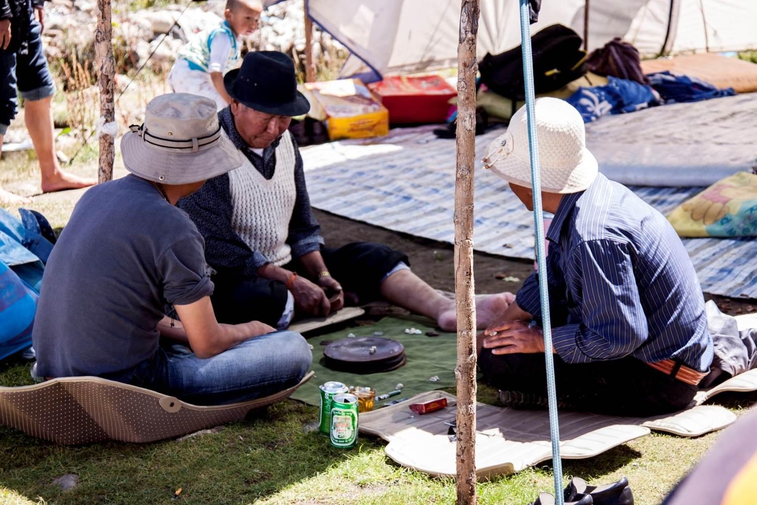 Aged Tibetan men love playing traditonal game:throwing dices.