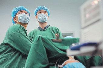 Doctor dedicates career to medical education During a laparoscopic surgery last year, Lu Yun and a colleague check their progress. [Photo/China Daily]