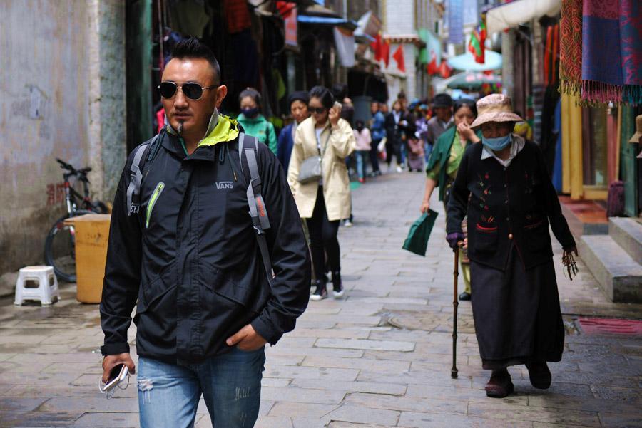 Lobsang Tashi walks on the street of Lhasa on Aug.6, 2015. [Photo/Xinhua]