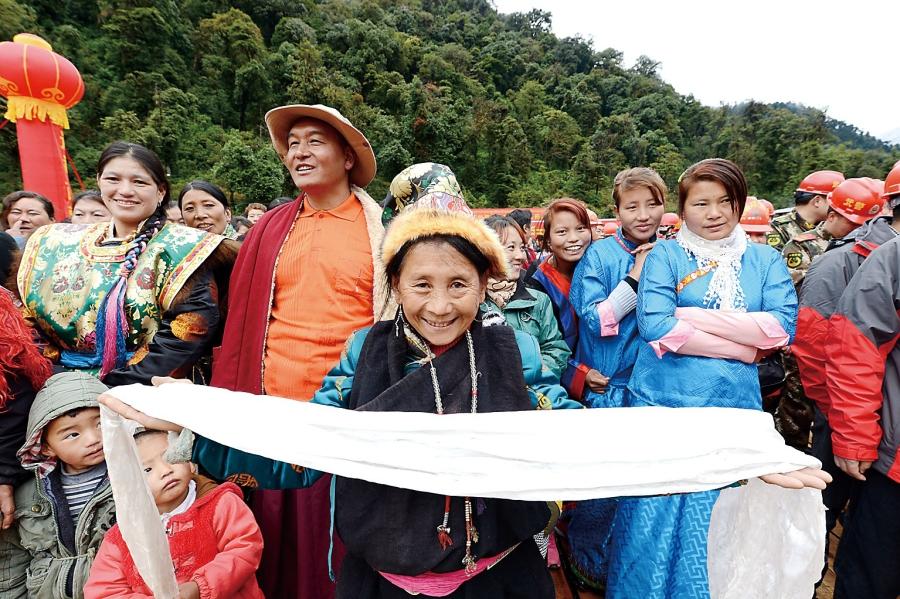 On October 31, 2013,  the highway from Medog County to Bome County, which is  117 km long, was completed. The photo shows that  a 76-year-old mother of Moinba [Manba] nationality attends the opening ceremory with a pure white hada to express  her profound gratitude for the Communist Party of China and our nation.