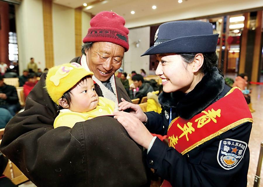 At the first day of Spring Festival travel period, Liu Linlin, Secretary of Youth League Committee at Lhasa Railway Public Security Office, is caring for little passenger. [Photo/Hu Chuanxin]