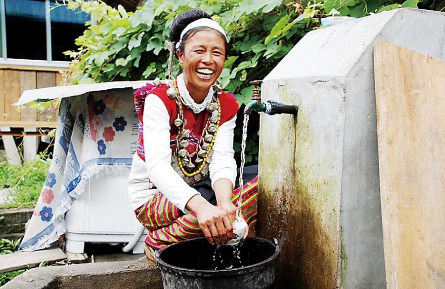 A villager is using tap water in her own yard.[Photo/Mai Zhengwei]