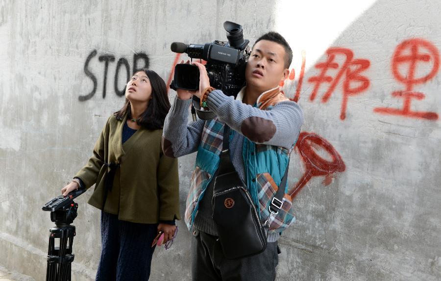 On November 7, 2015, the journalists from Lhasa Television Station are having an interview at Barkhor Street in Lhasa. Although Tibet is high-cold and oxygen deficit, the journalists who record Tibet work in areas under the most harsh conditions and they tell the world what is happening on the plateau to let more people know about Tibet and the lives of Tibetan people.[Photo/Jue Guo]