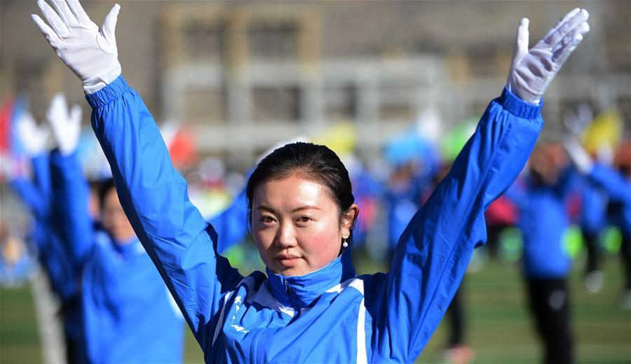 On November 14, 2015, the masses from Chengguan District, Lhasa are doing radio gymnastics. On that day, Winter mass sports activity is launched in Lhasa to let more masses to be involved in sports and exercises that are fit for people living on the plateau, such as group dancing, tai chi, broadcast gymnastics and walking ect. [Photo/Jue Guo]