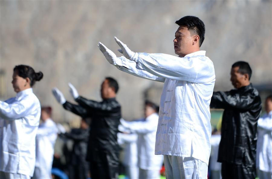 On November 14, 2015, the masses from Chengguan District, Lhasa are doing tai chi. On that day, Winter mass sports activity is launched in Lhasa to let more masses to be involved in sports and exercises that are fit for people living on the plateau, such as group dancing, tai chi, broadcast gymnastics and walking ect. [Photo/Jue Guo]