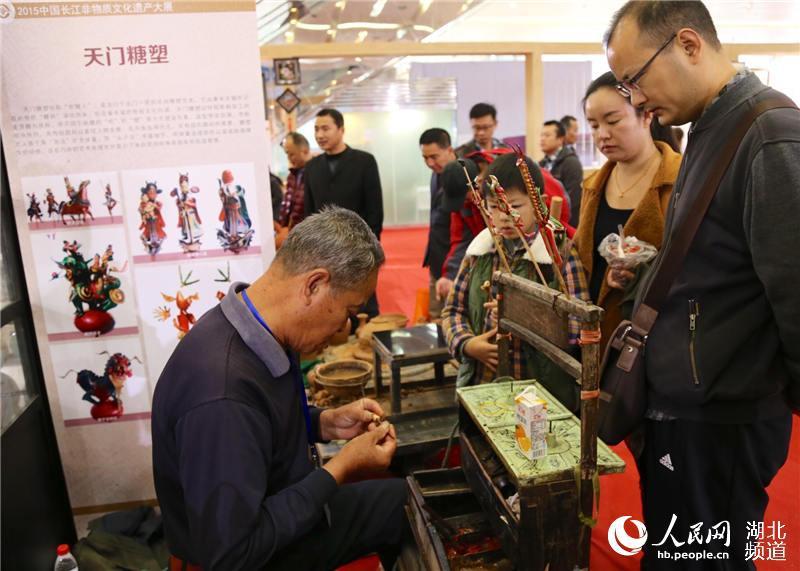 80-year-old Chen, the third generation of successor of Tianmen sugar sculpture, blows sugar figures for children. (Photo Source: people.cn)