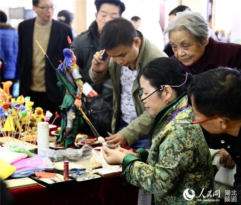 Many people observe the flour sculpture at the exhibition. (Photo Source: people.cn)