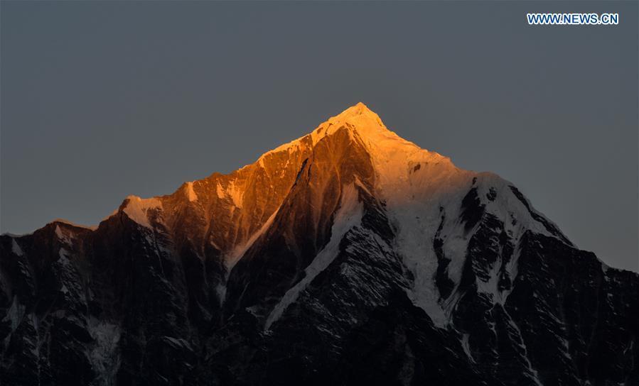 Sunshine casts on a snow mountains in Gyirong Township of Gyirong County, southwest China