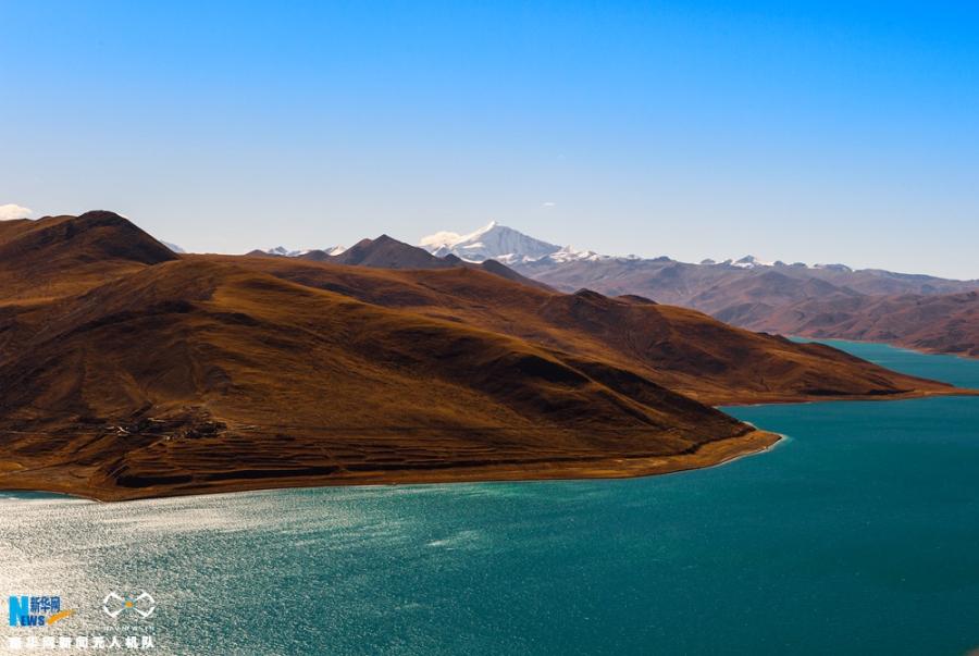 Photo shows the scenery of snow mountain and Yamdrok Lake in early winter. [Photo/Xinhua]Yamdrok Lake is a freshwater lake in southwest China’s Tibet Autonomous Region, it is one of the three largest sacred lakes in Tibet. It is over 72 km long. The lake is surrounded by many snow-capped mountains and is fed by numerous small streams. The lake has an outlet stream at its far western end.