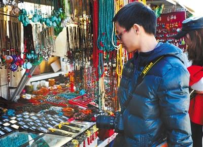 Photo shows that one tourist is purchasing souvenirs at the square of Jokhang Temple. [Photo/China Tibet News]In recent years, Tibet Autonomous Region has been striving to promote the Tibetan tourism brand of "Winter Tour to Tibet". The corresponding tourism products and tourism routes with so many highlights are developed, making winter tour to Tibet not less attractive than that in summer. At present, "Winter tour to Tibet" is especially hot, attracting a large number of overseas tourists stop and hang around.In winter, people in Tibet can enjoy warm sunshine and clear blue sky, which has changed tourists