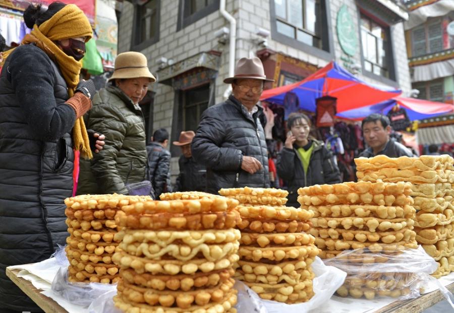 ​As the 2017 Tibetan New Year is coming near, more and more customers in Lhasa choose to purchase goods for use during the Tibetan New Year in the market at streets. Photo taken on Feb. 21, 2017 shows that citizens are purchasing “Dega”(a kind of festival tribute) in the special purchases market for Tibetan New Year. [Photo/China Tibet News]