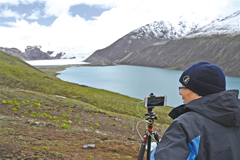 Photo taken on June 9 shows Mr. Sun from Hunan Province taking photos of snow-capped Sapu Mountain. [China Tibet News/ Wang Yifei, Lhapa Drolma, Chodron]